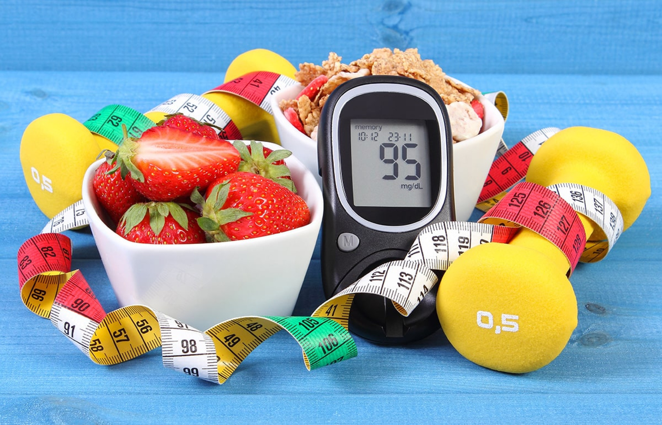 bowl of strawberries, step counter, weights, and tape measure
